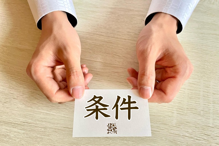 紙に書かれた条件を示す手
